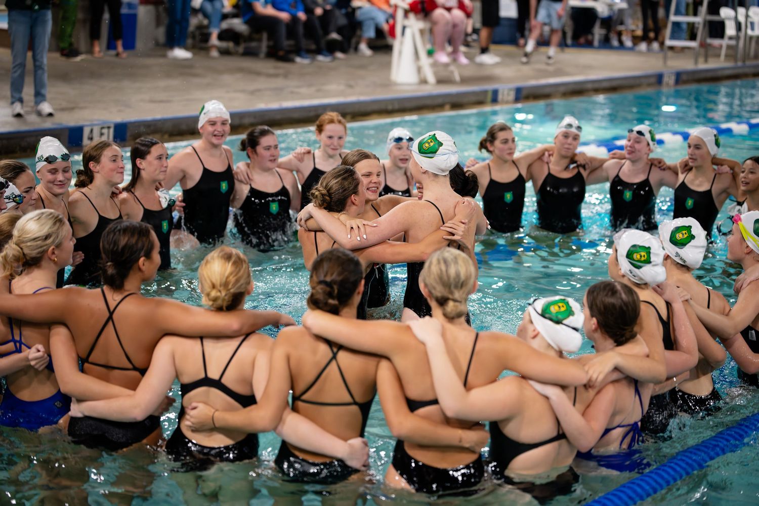Synchronized swimmers perform a group routine in a pool with coordinated leg movements above water.