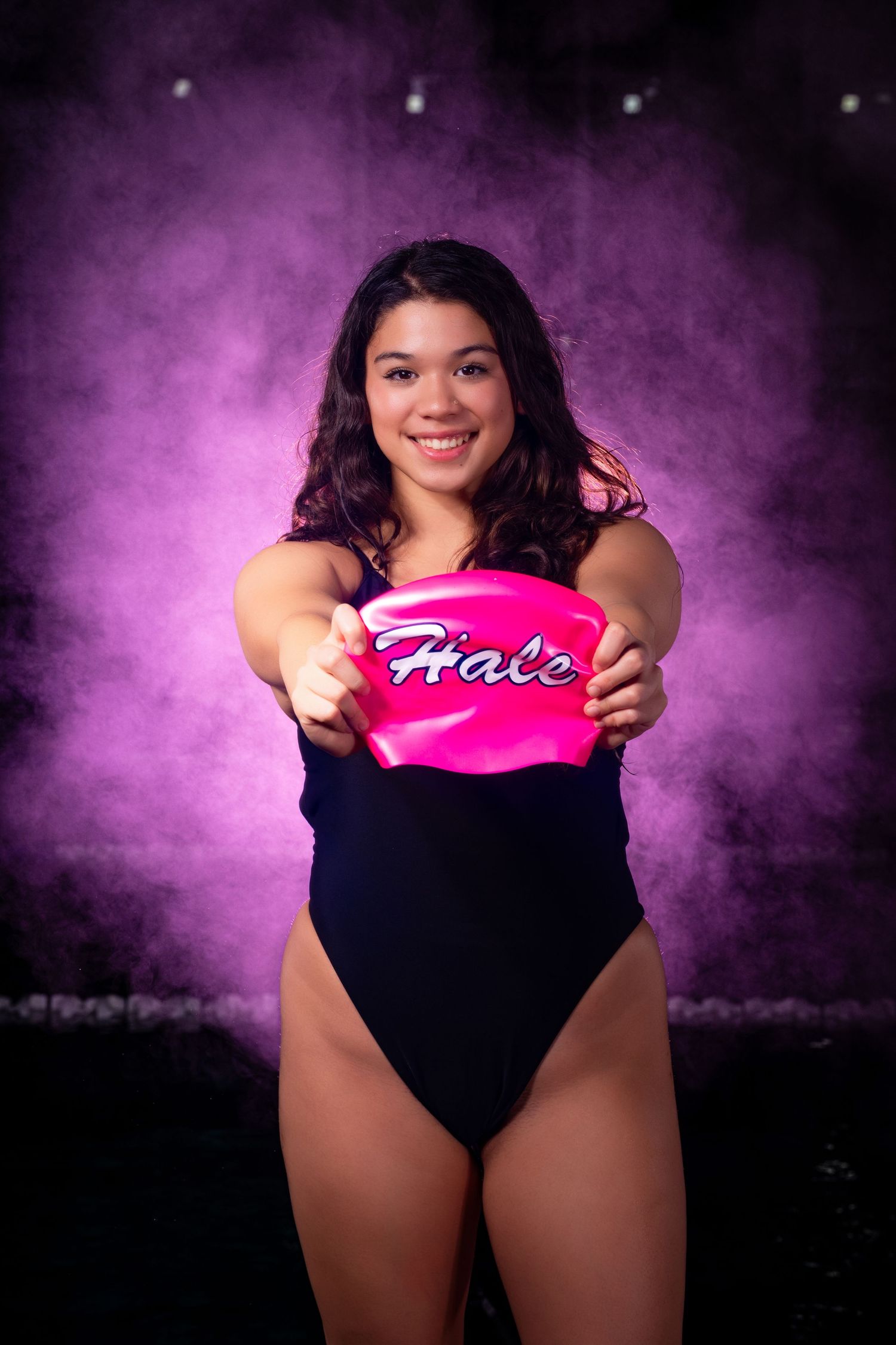 A series of photos showing someone in a black leotard holding a pink heart against a purple smoky background.