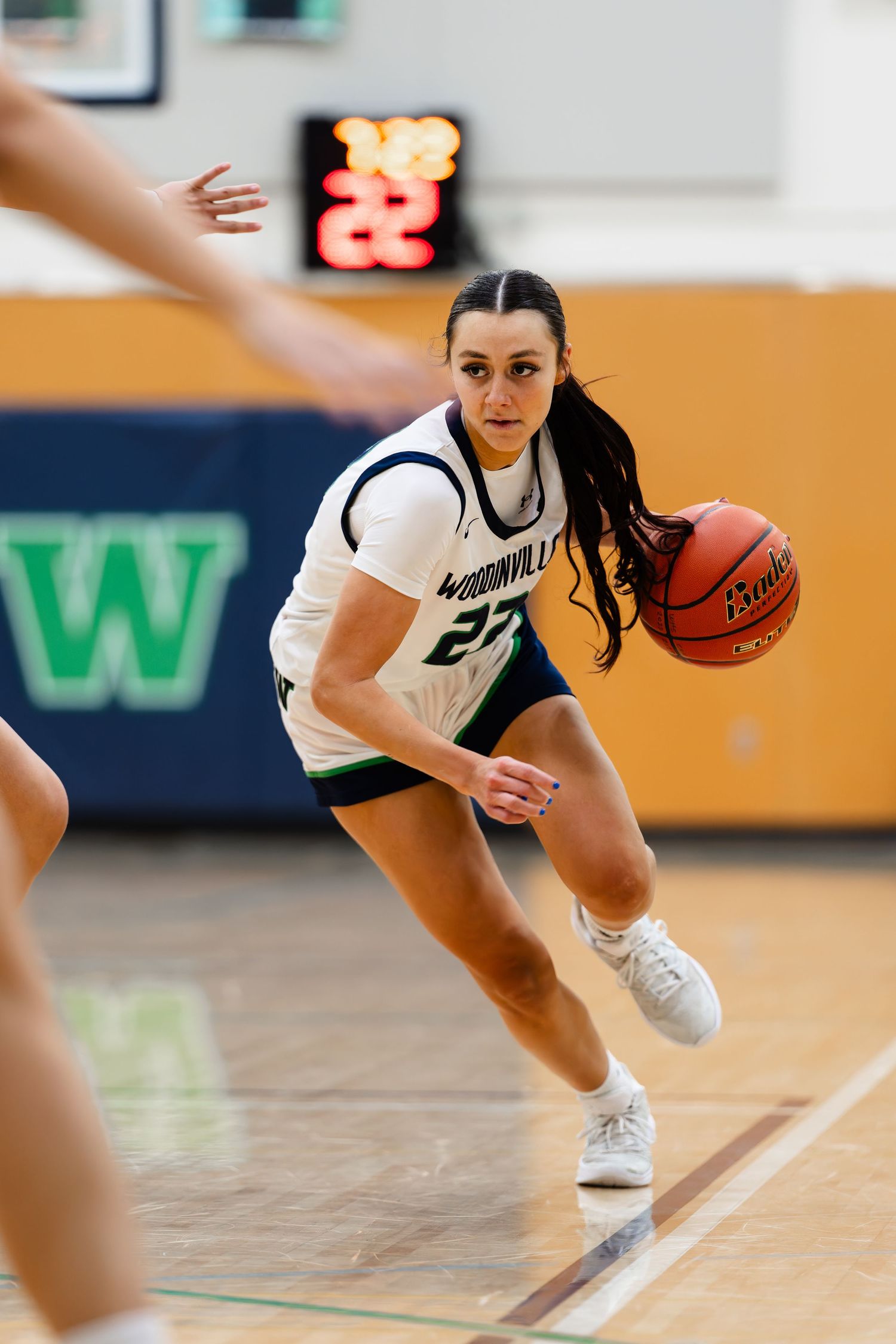 Basketball player dribbles low while making a quick move on the court during an intense game.