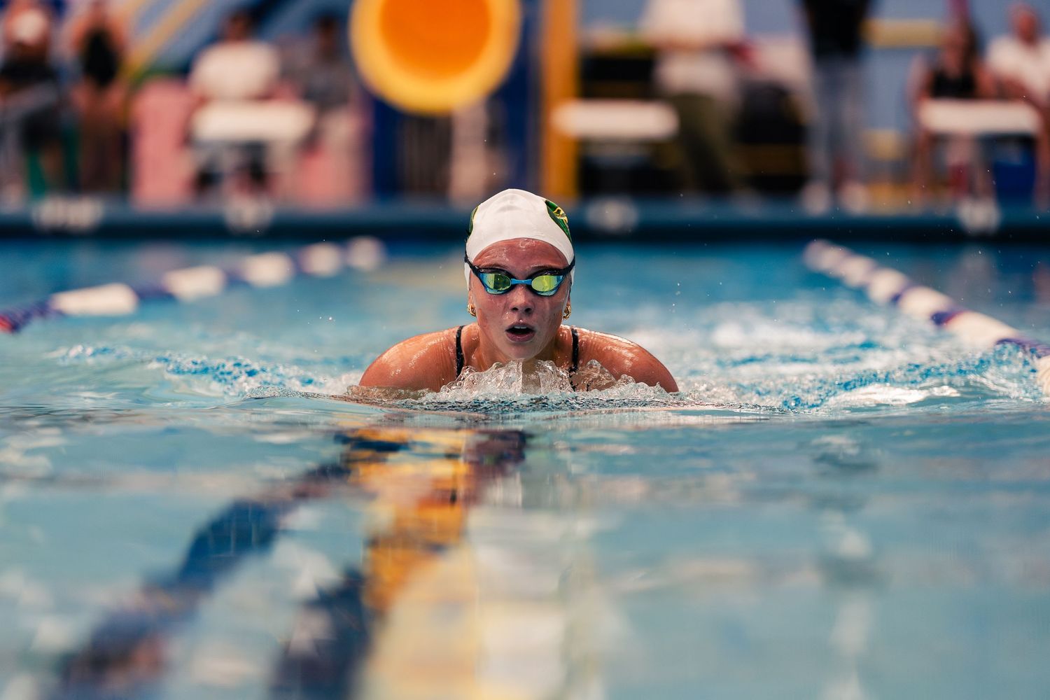 Competitive swimmers race through bright blue pool lanes during an intense swimming competition.