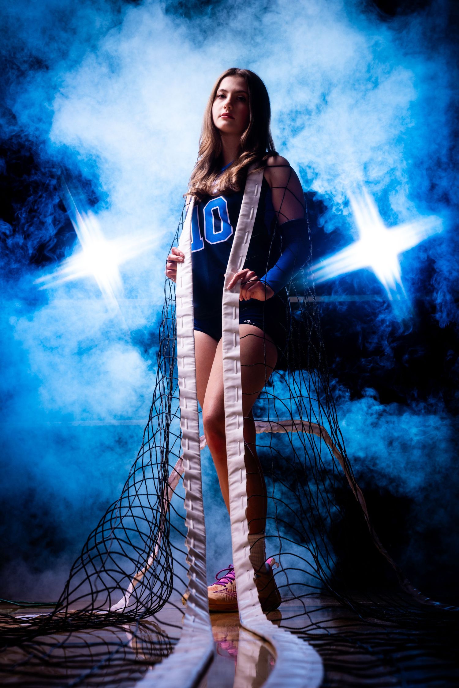 Athletic figure in uniform poses with dramatic blue smoke and star lighting effects.