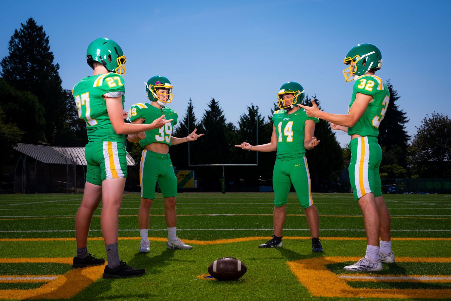 A sequence of football players in green uniforms demonstrating a play formation on a sunny field.