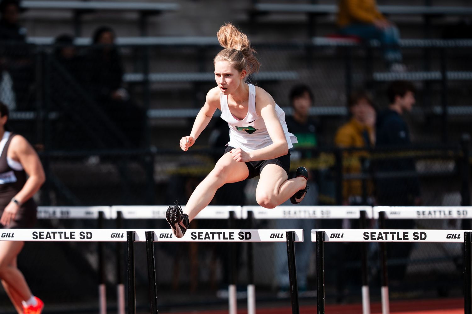 Track athlete clears hurdles during an indoor competition at Seattle stadium.