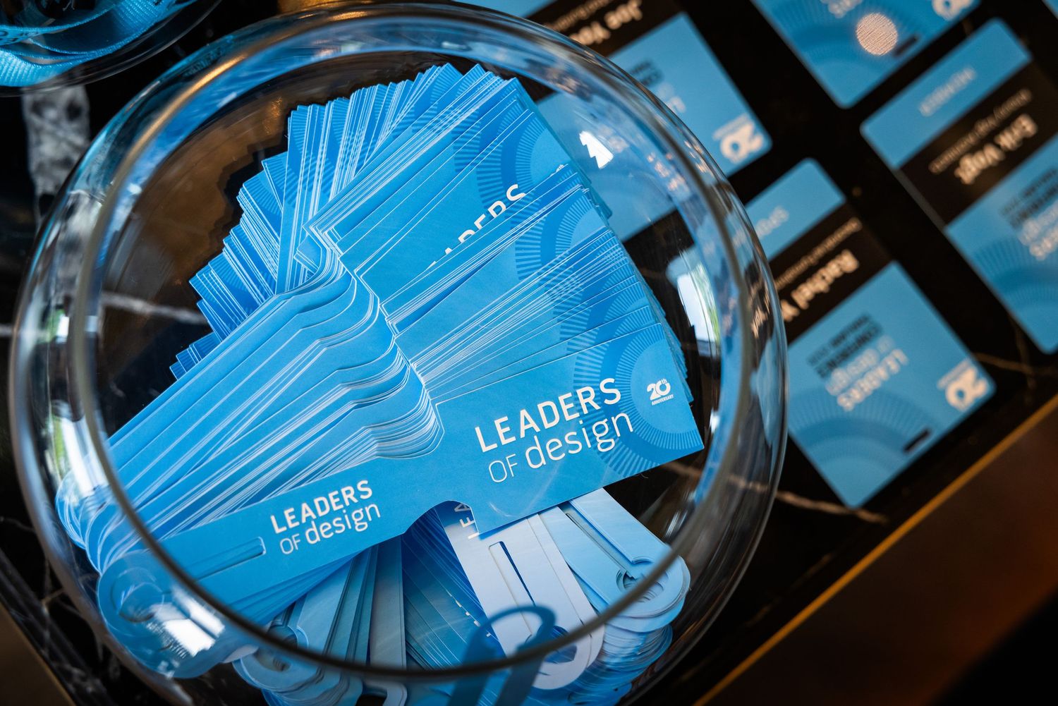 A bowl filled with blue Leaders by Design conference cards at a registration desk.