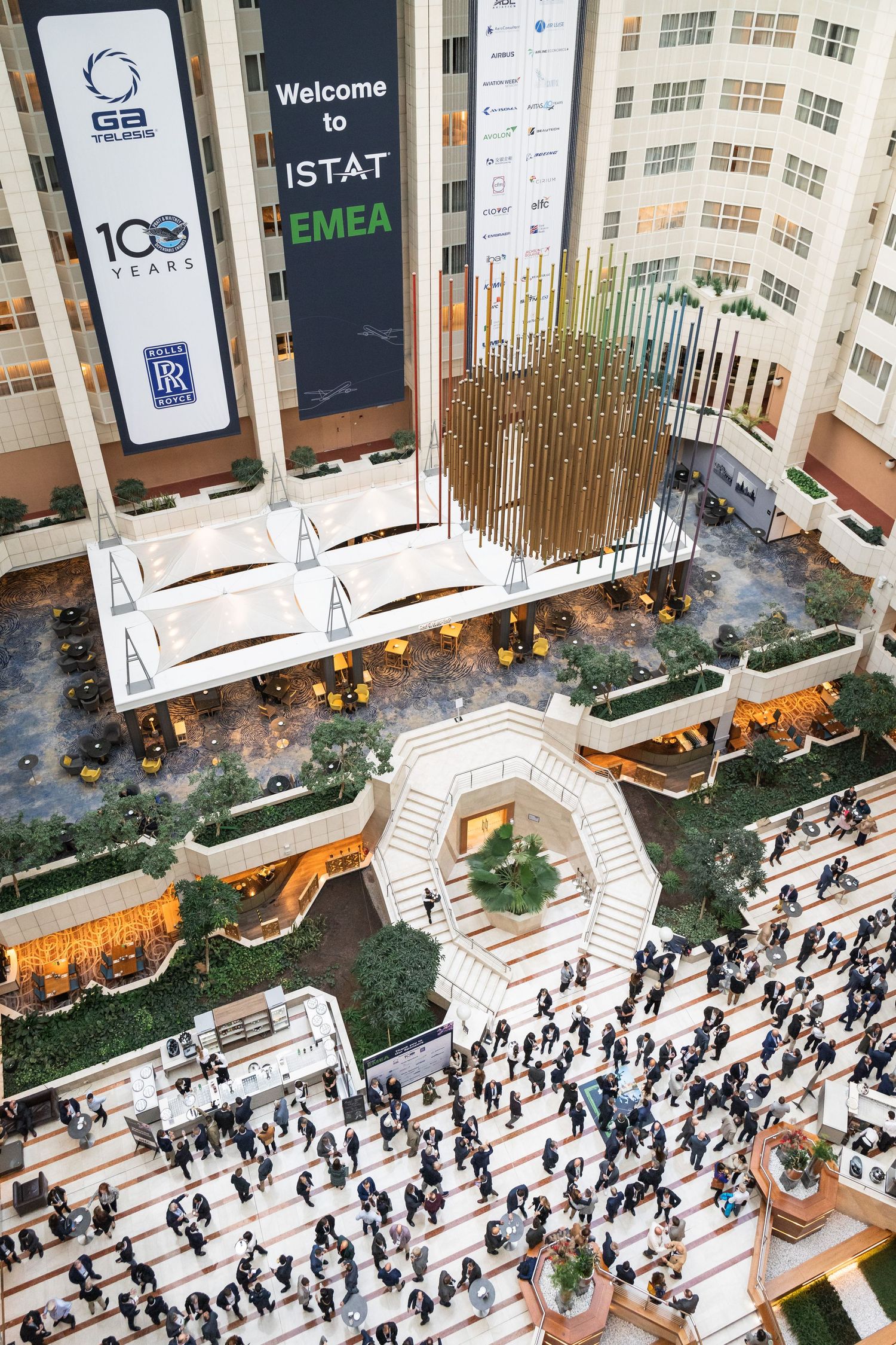Aerial view of hundreds of business attendees filling a modern atrium at the ISTAT EMEA conference.