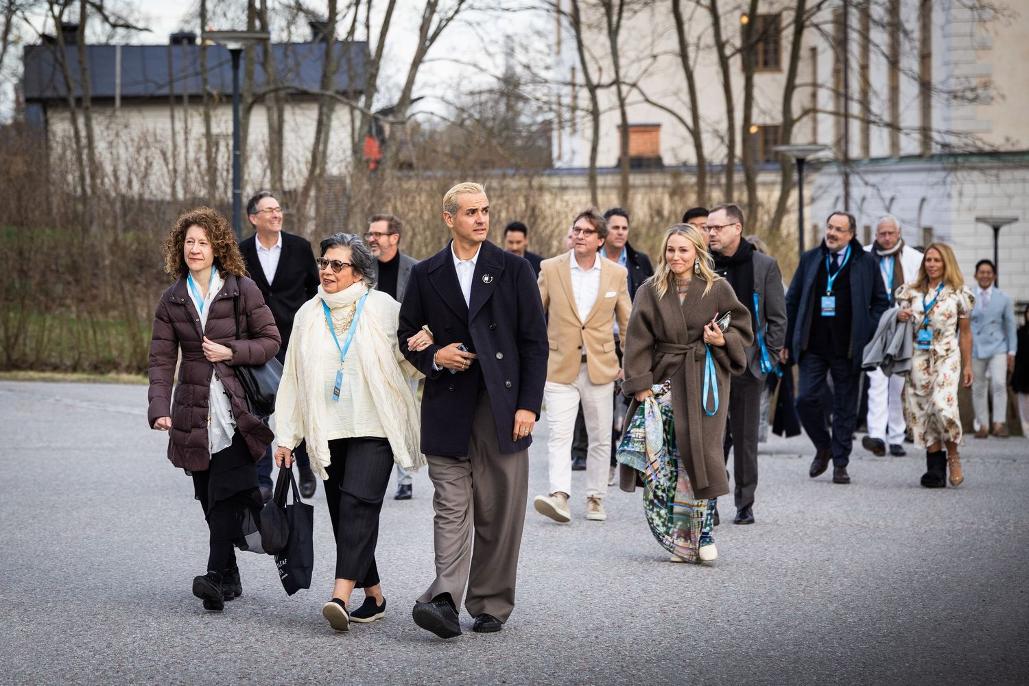 Large group of design conference attendees walking together outdoors in Stockholm during daytime event.
