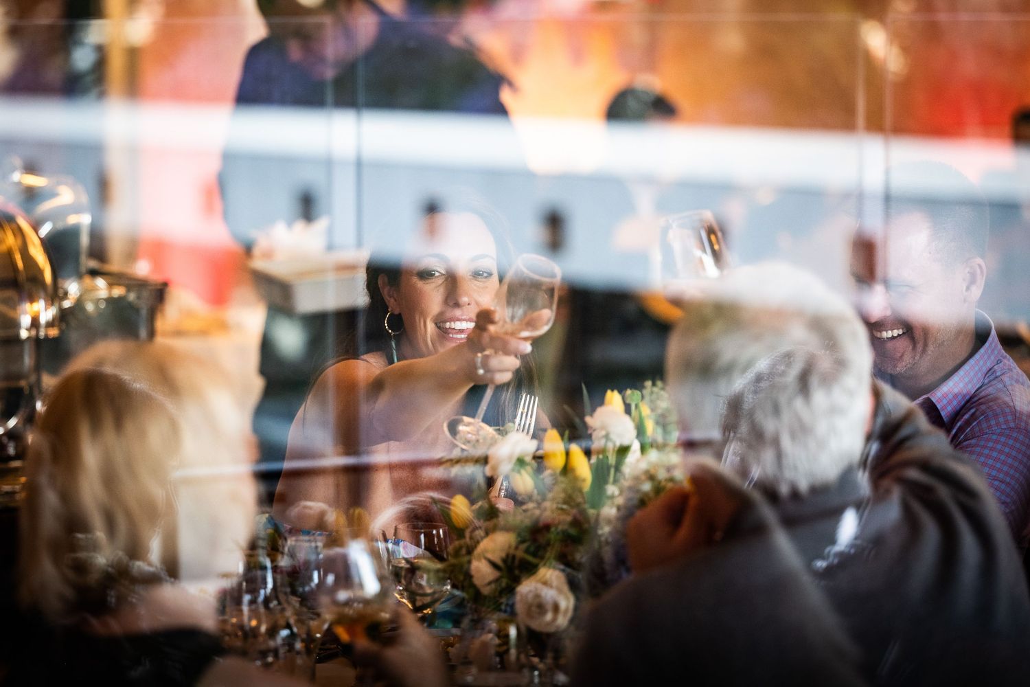 Guests clink wine glasses in a cheerful toast at an elegant dinner party event.