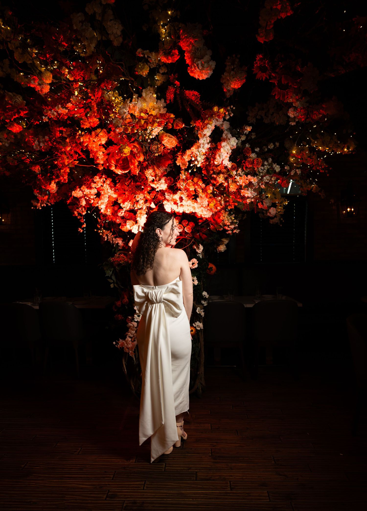 A dramatically lit photo of the bride to be at the restaurant she is celebrating her bridal shower at in Freehold, NJ