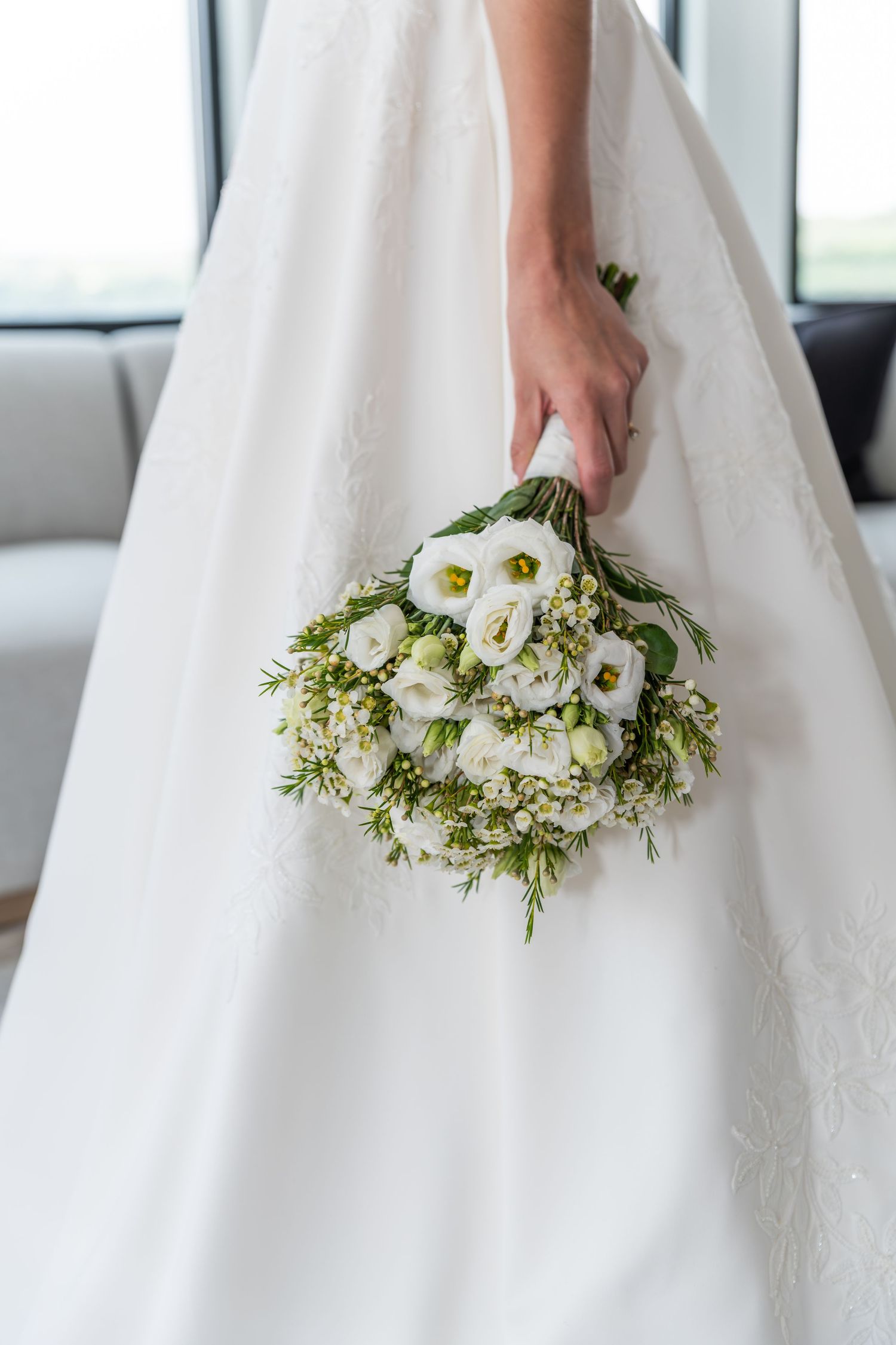 A close-up shot of the bride's hand holding her flowers at her side in Bayonne, NJ
