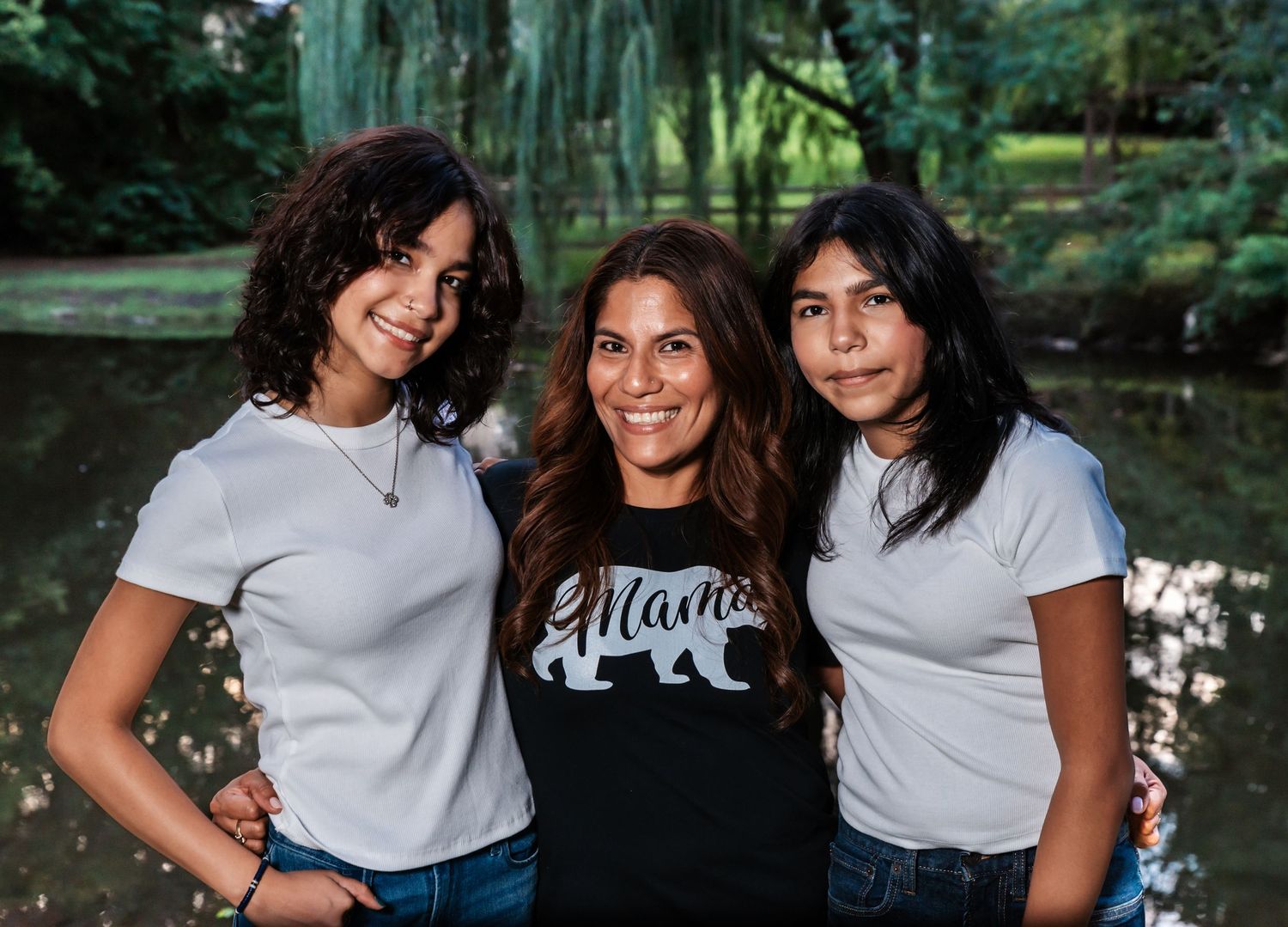 A mom poses with her two daughters during their family photo session in a park in Nutley, NJ