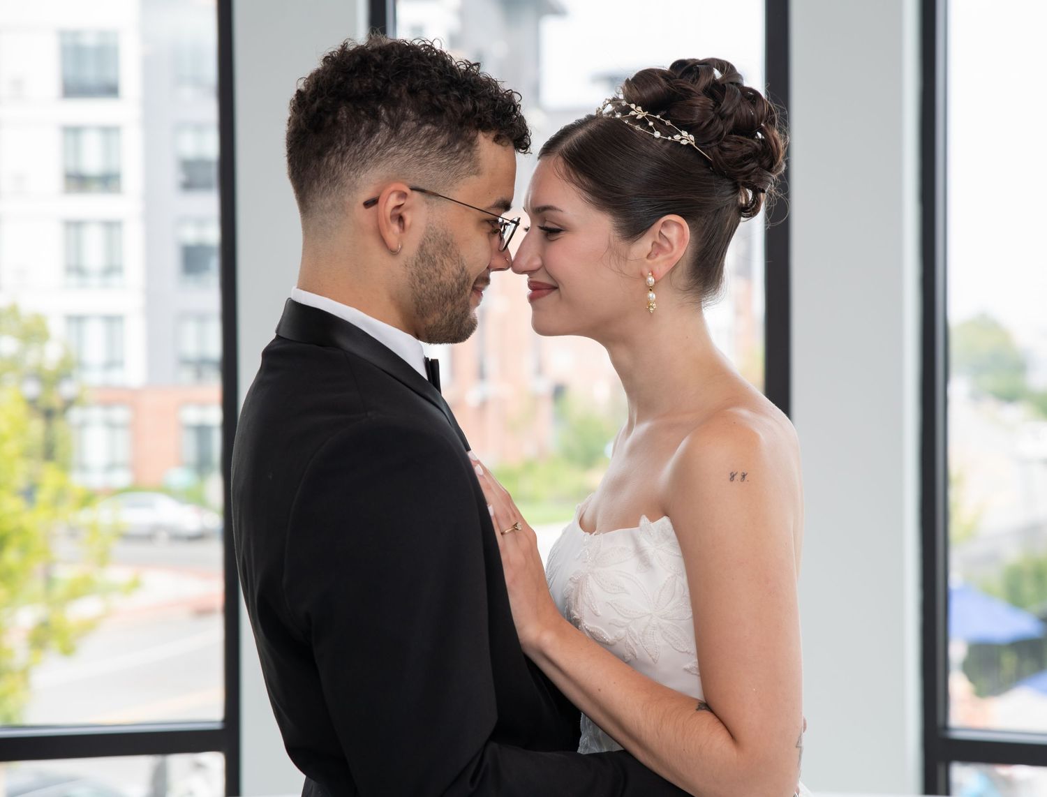 A bride and groom are nose to nose and smiling for a portrait in Bayonne, NJ