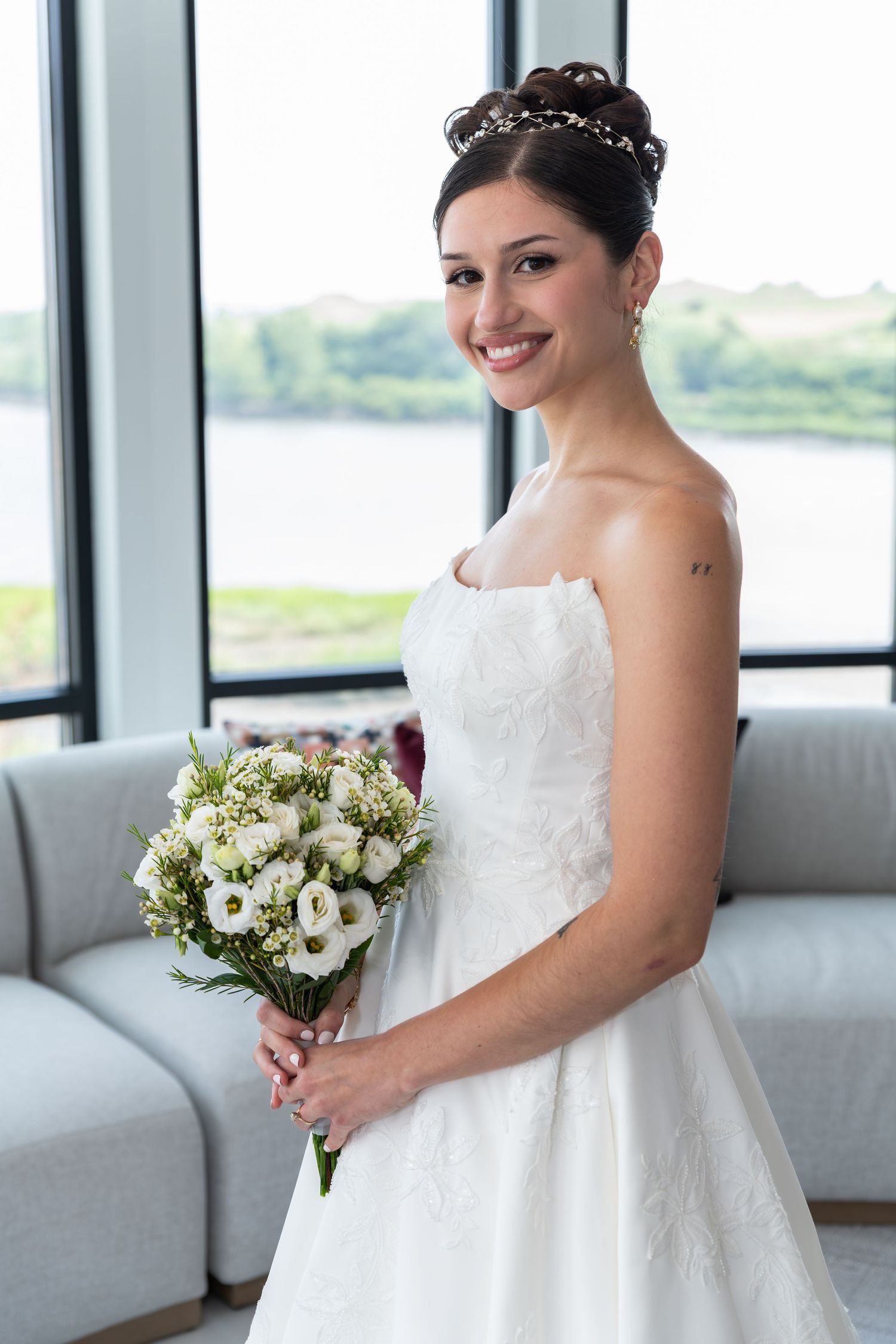 A portrait of a bride holding her bouquet and looking at the camera, smiling in Bayonne, NJ