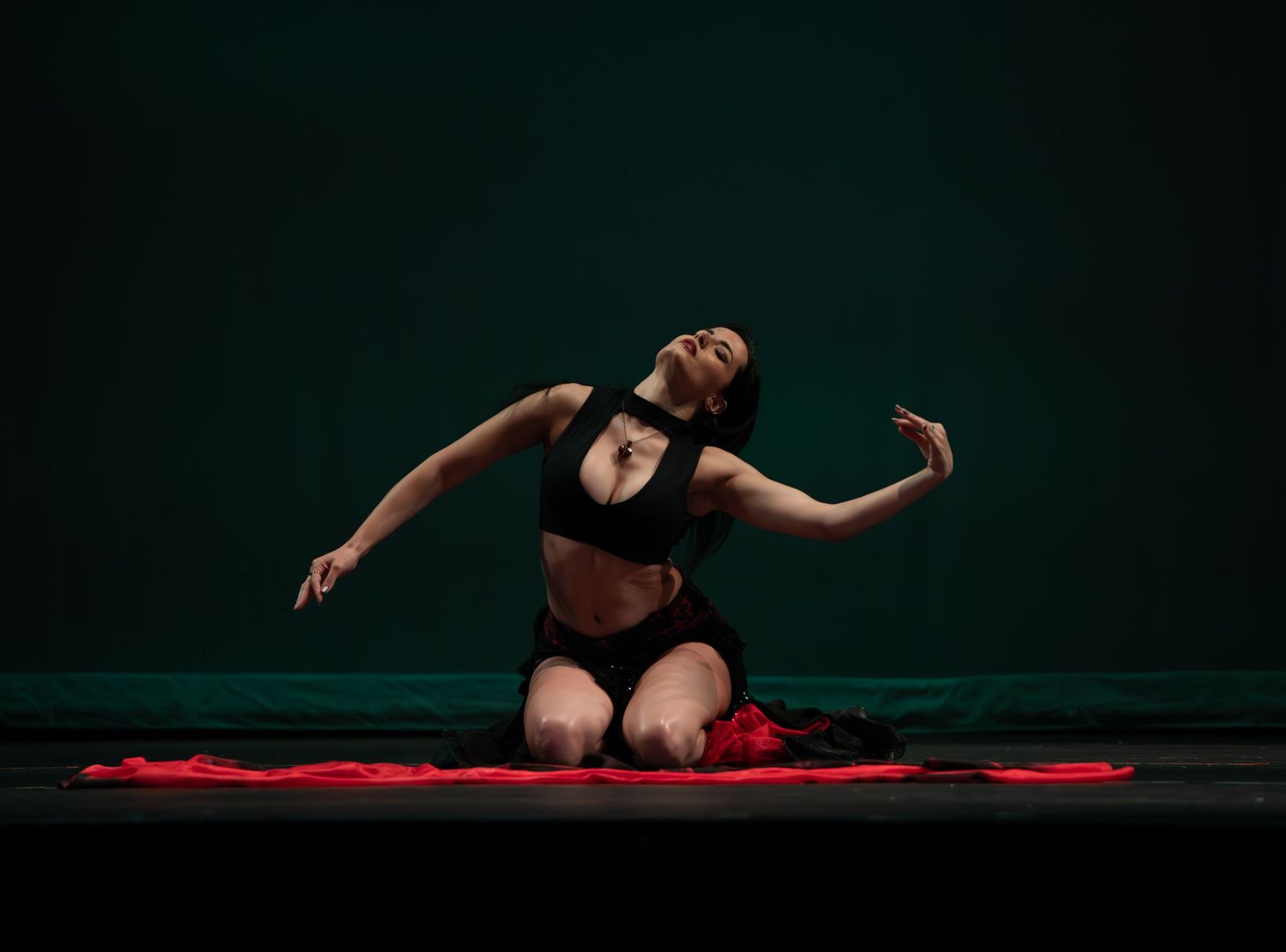 Female dancer performing at a dance recital in Maywood, NJ, captured in motion with graceful expression and vibrant costume on stage