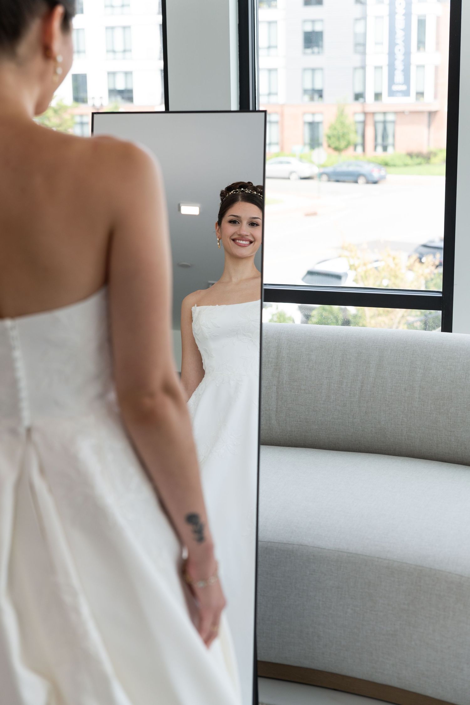 A portrait of a bride standing in her wedding dress and looking the mirror in Bayonne, NJ