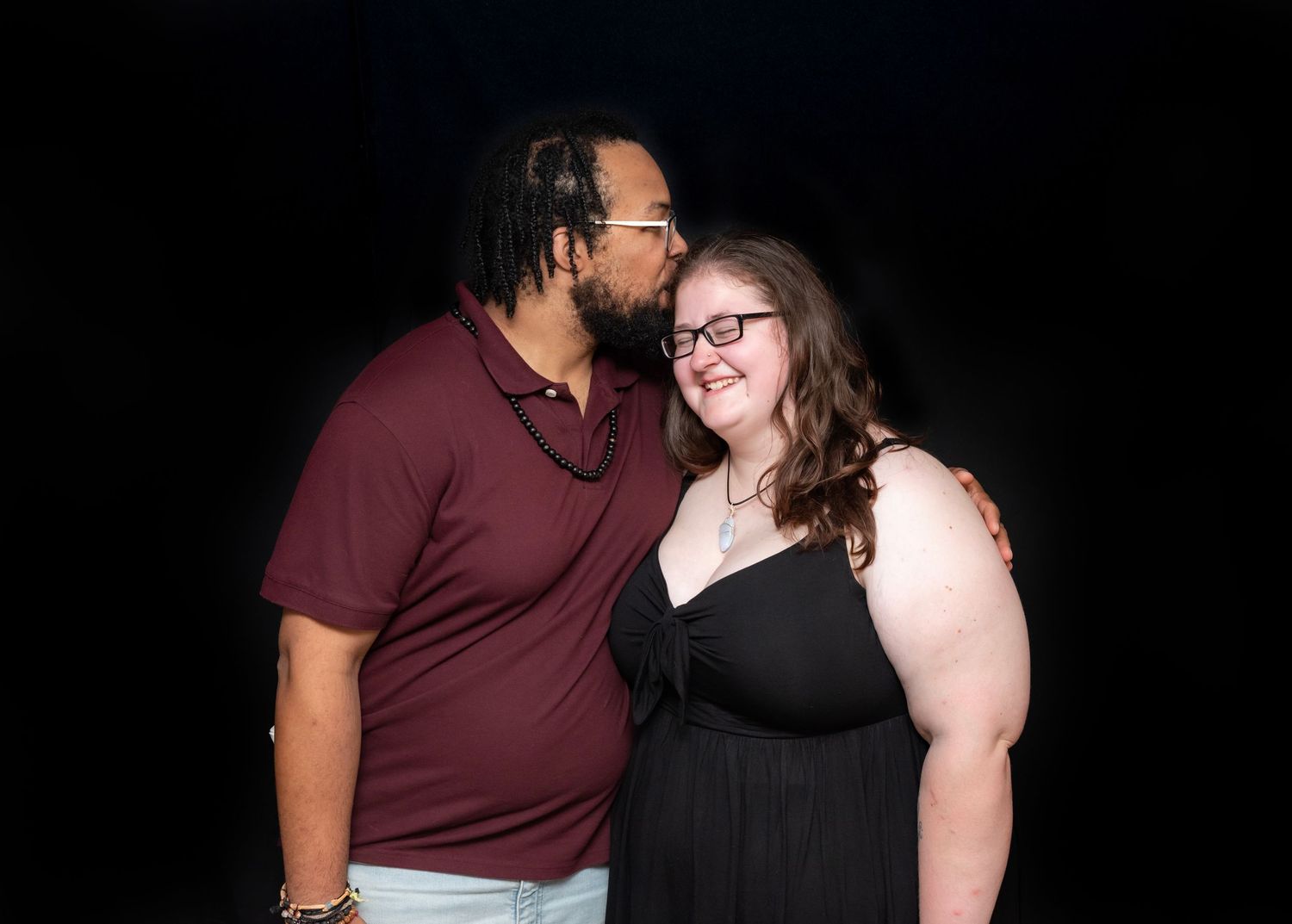 A couple pose for a portrait as the man kisses the woman on the head during a college graduation party in Hewitt, NJ