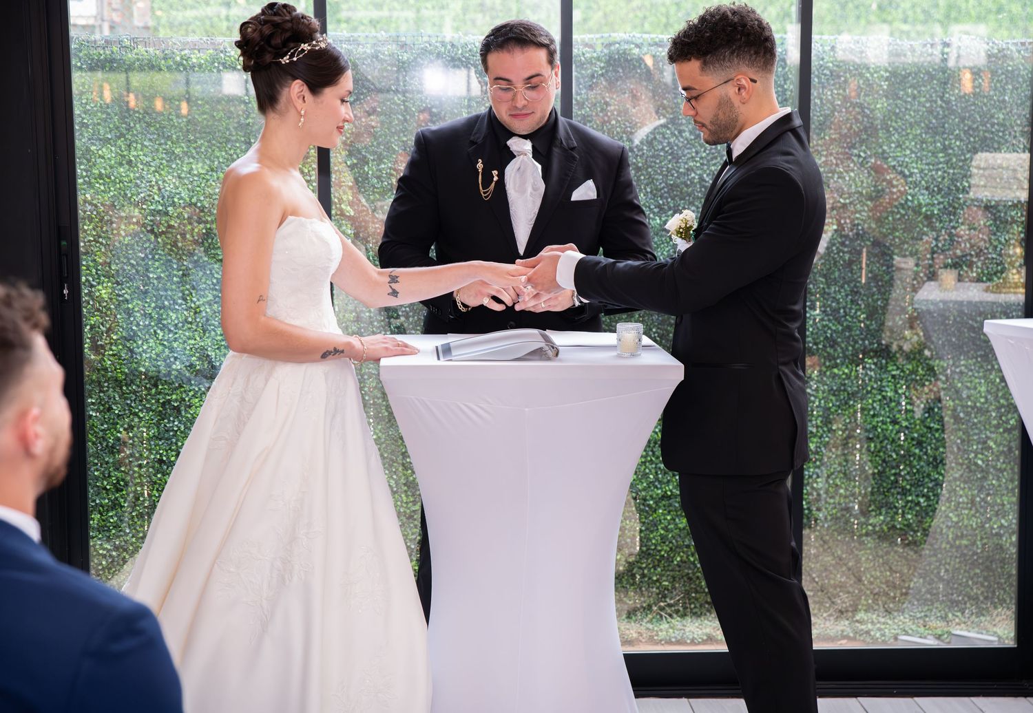 The groom is putting the wedding ring on the bride's finger in Bayonne, NJ