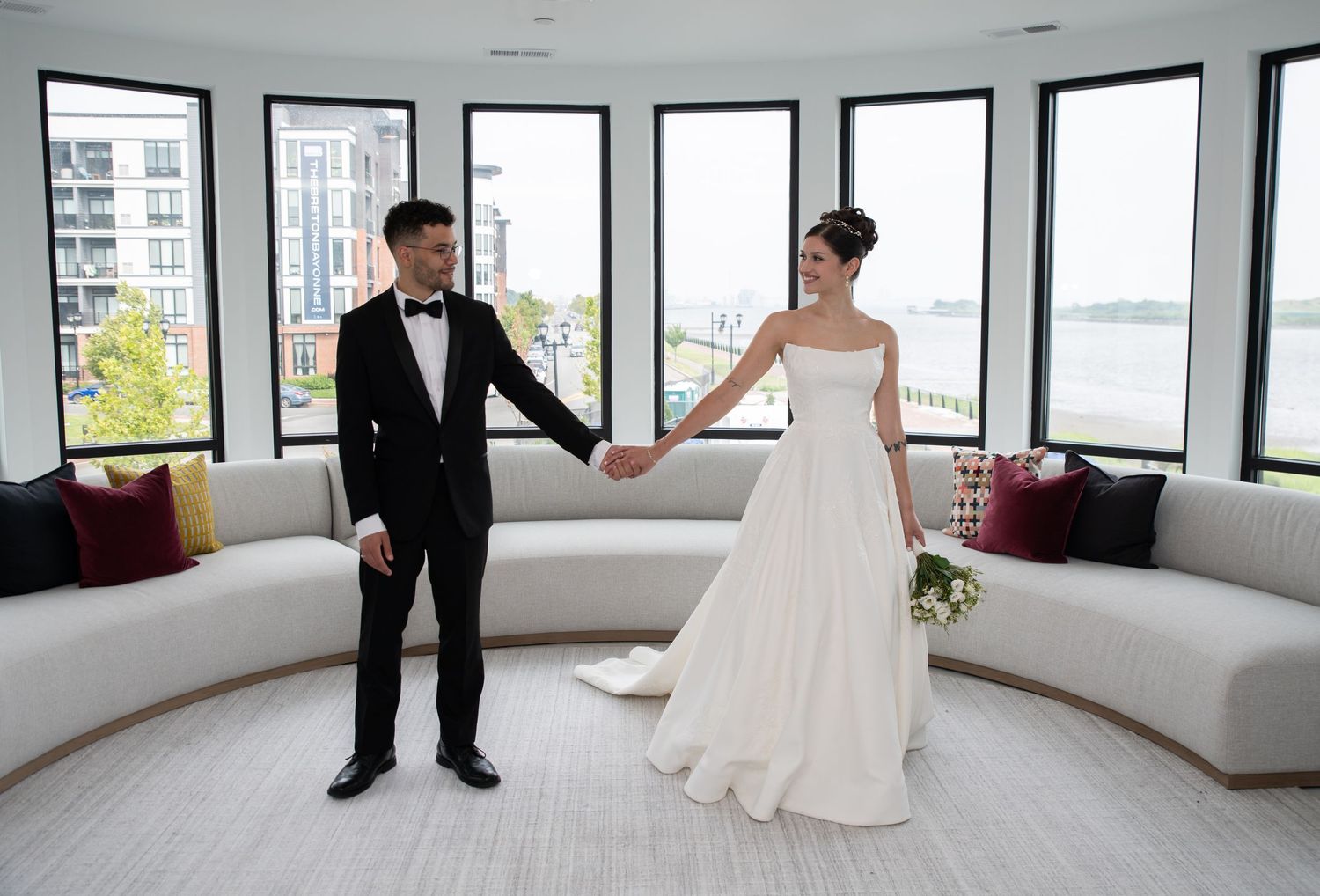a bride and groom holding hands looking at each other and smiling for portraits in Bayonne, NJ