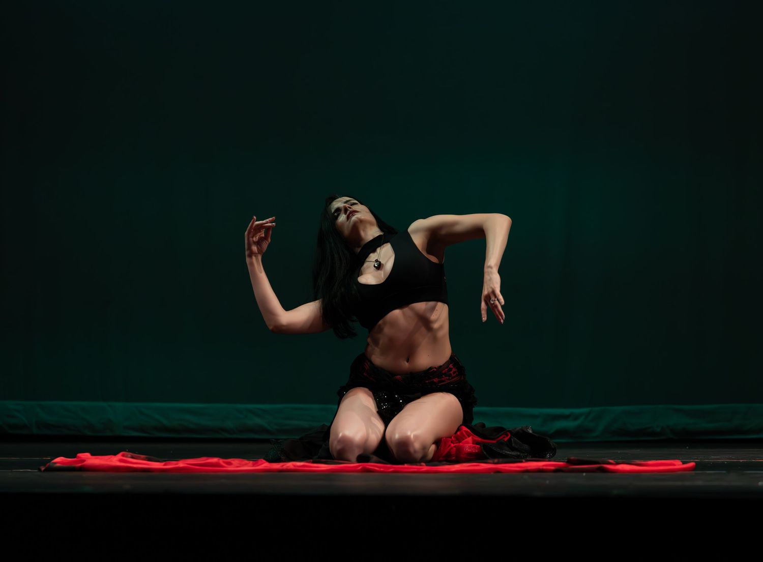Female dancer performing at a dance recital in Maywood, NJ, captured in motion with graceful expression and vibrant costume on stage