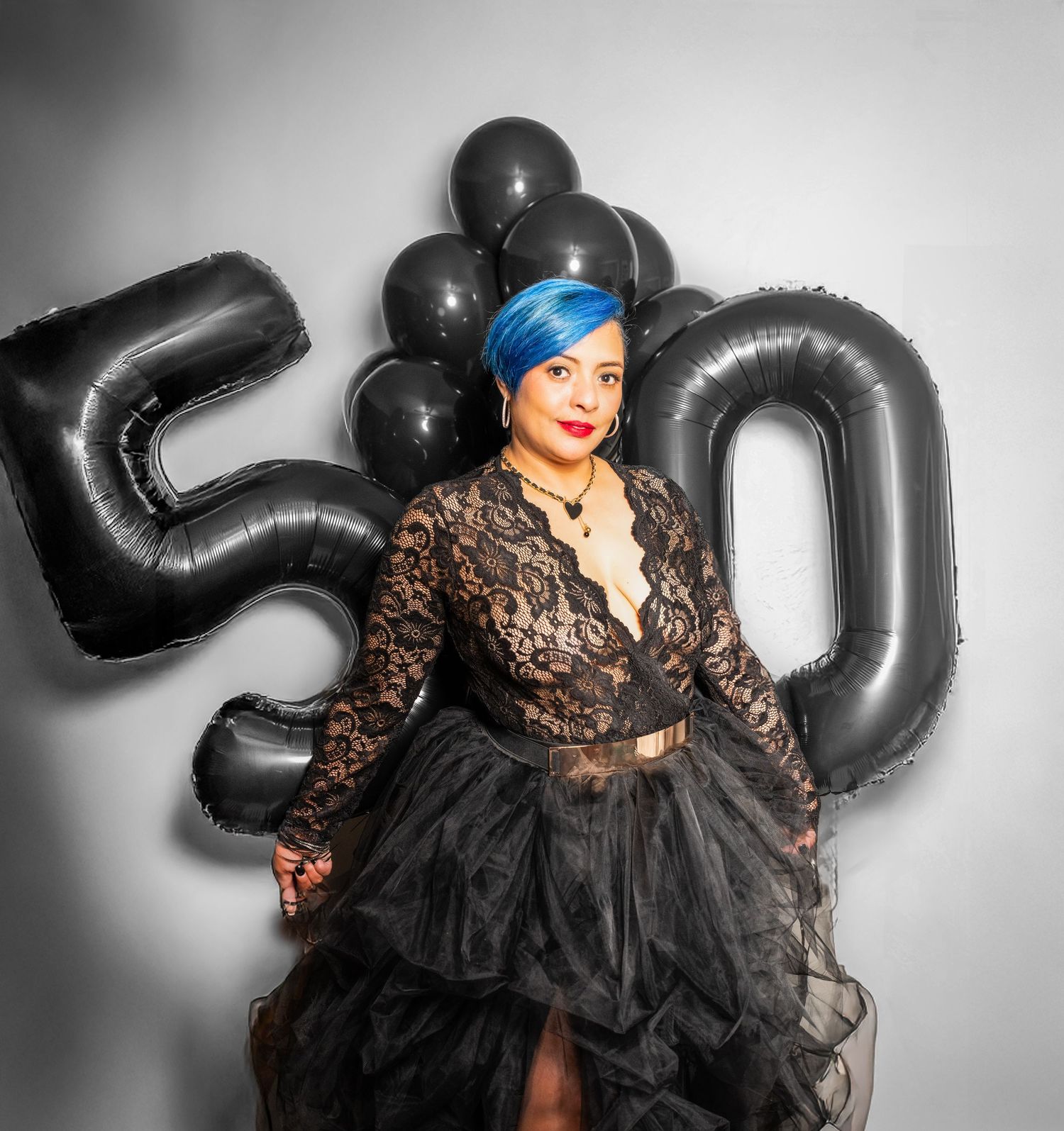 A portrait of a woman standing and holding ballons that say 50 for her 50th birthday photo shoot in Woodridge, NJ