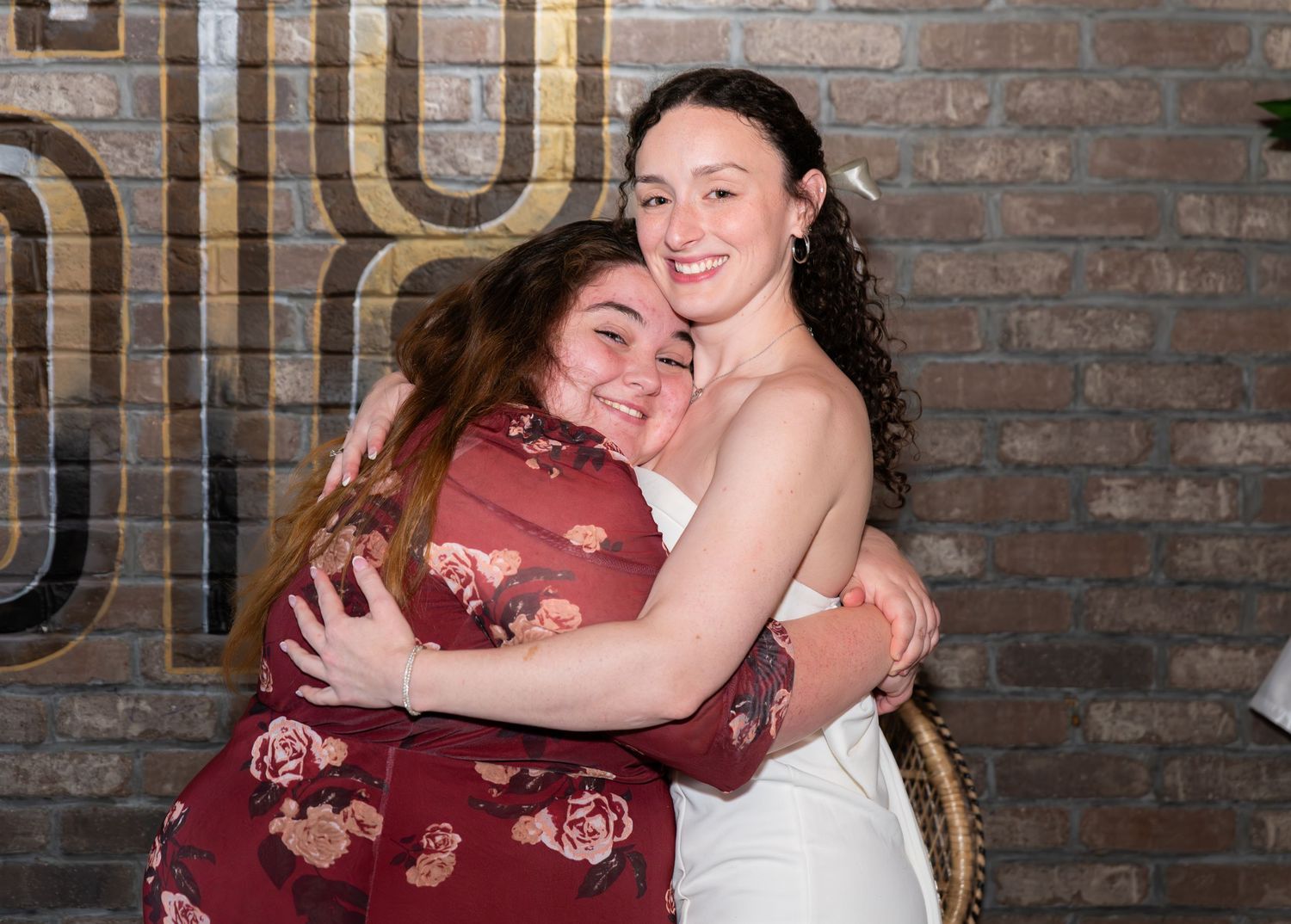 Two women posing joyfully for a photo together at a bridal shower and embracing in Freehold, NJ