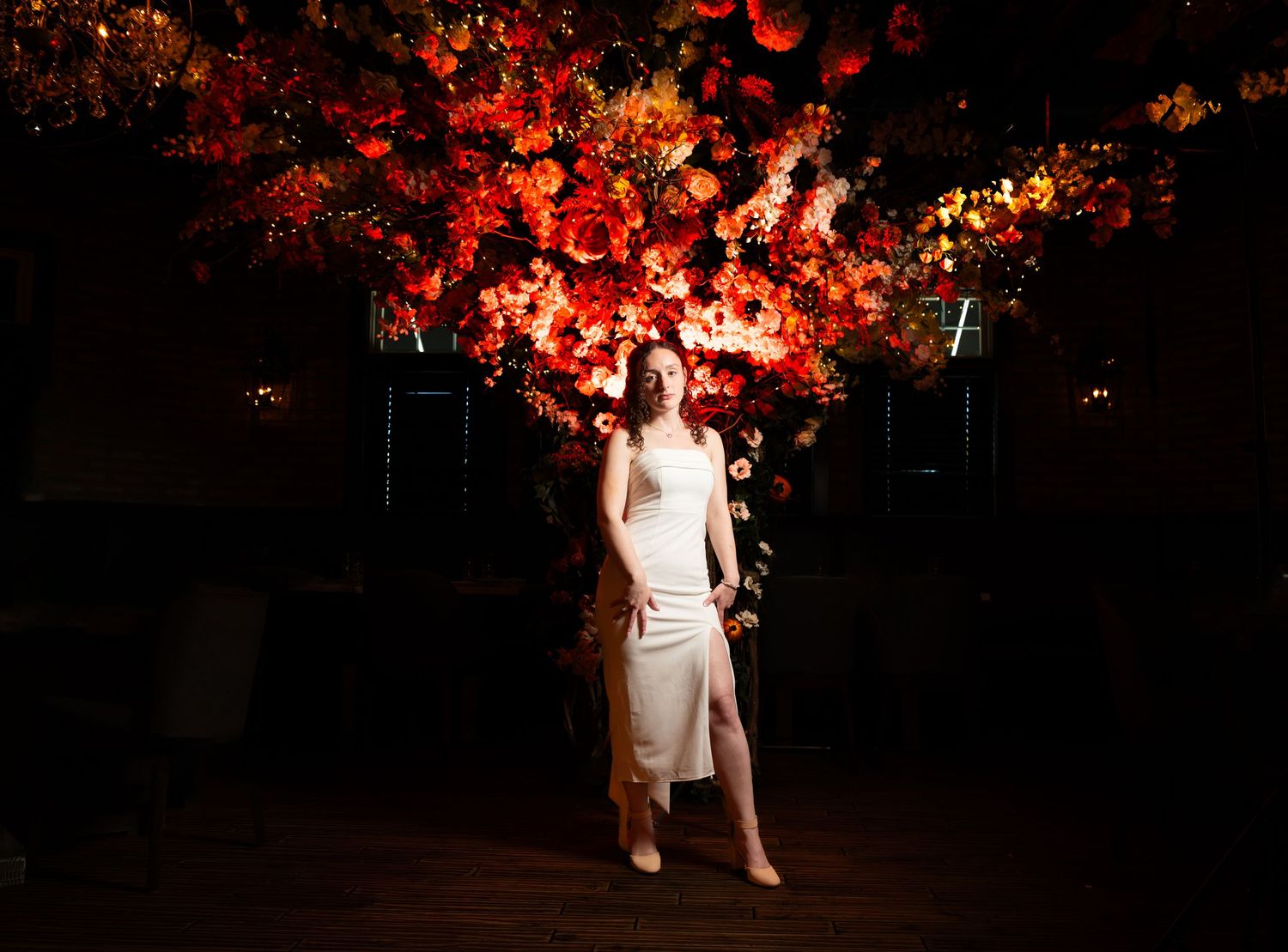 A dramatically lit photo of the bride to be at the restaurant she is celebrating her bridal shower at in Freehold, NJ