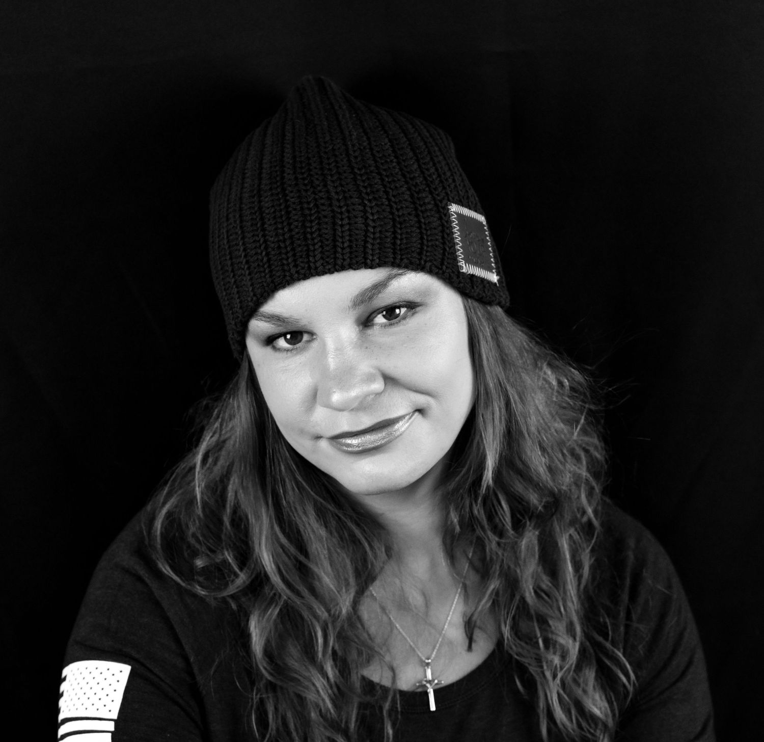 A black and white portrait of a woman wearing a hat and smiling for the camera in Clifton, NJ