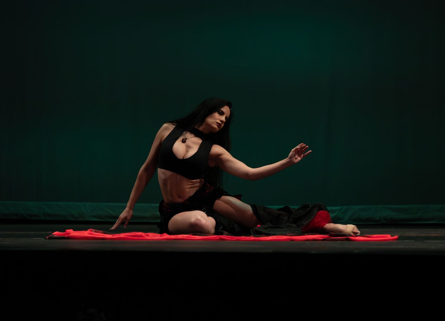 Female dancer performing at a dance recital in Maywood, NJ, captured in motion with graceful expression and vibrant costume on stage