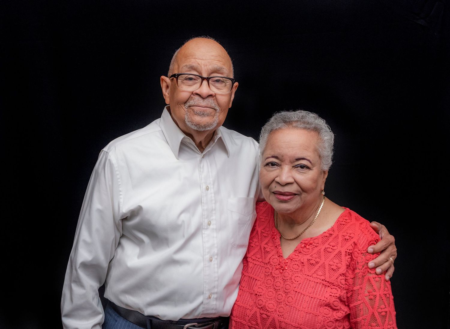 A senior couple posing and smiling for a portrait at a 60th birthday party in Montclair, NJ