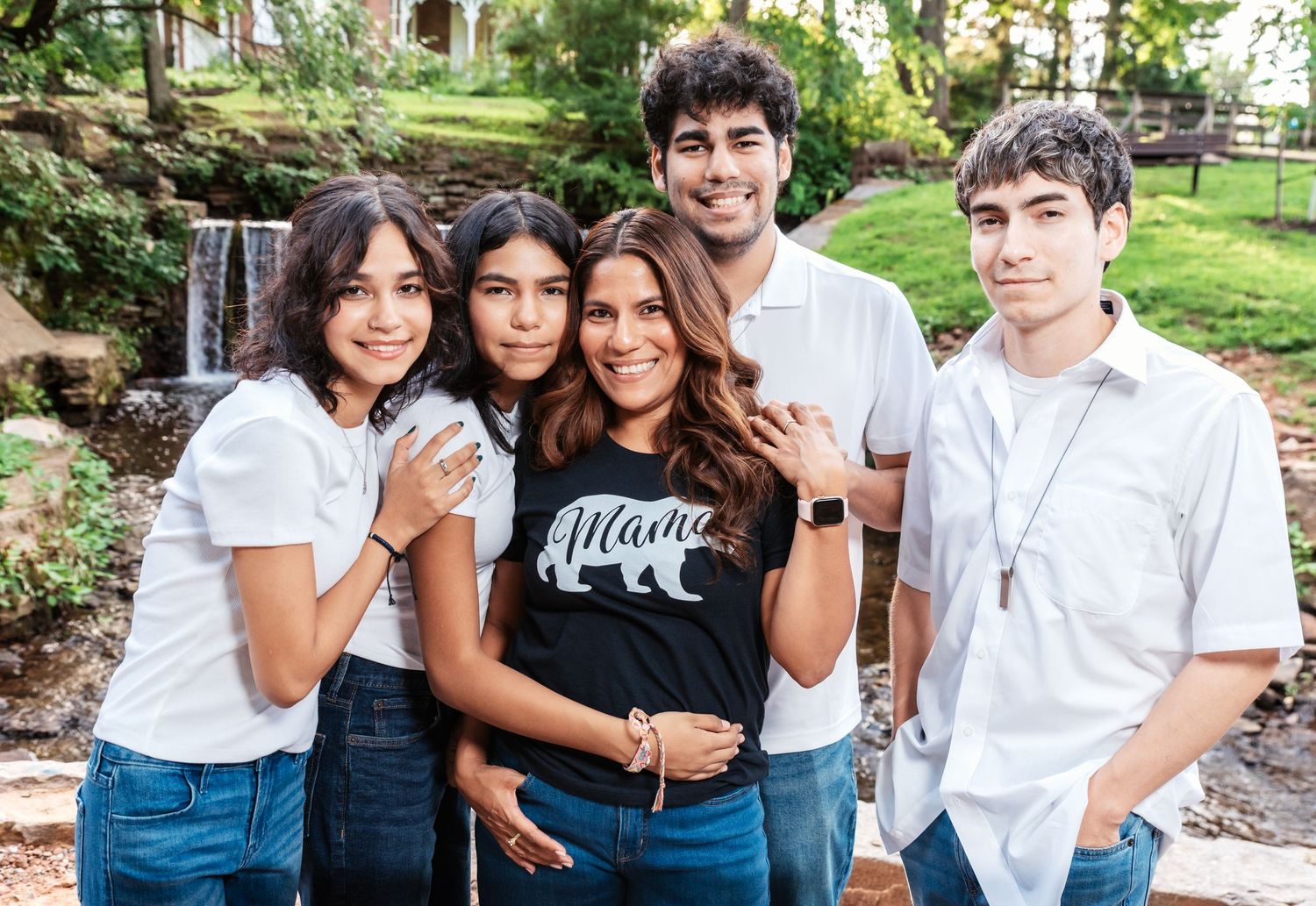 A mom with her 4 kids holds hands, and smiles during their family photo session in Nutley, NJ