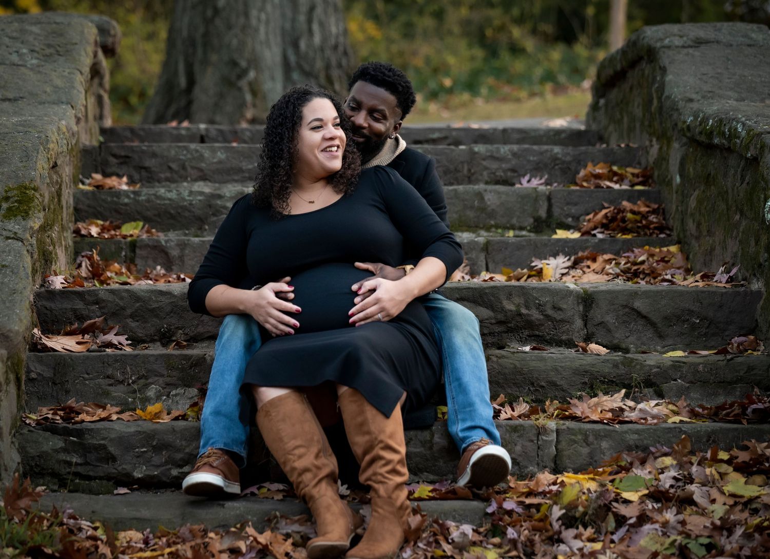 A couple during their maternity photoshoot and the husband is holding the mom's belly and their fingers are intertwined in Nutley, NJ