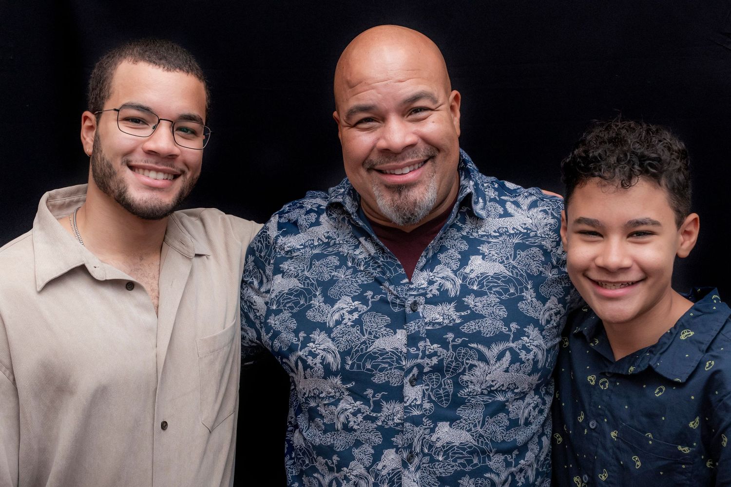 Three men posing for a portrait and smiling at a 60th birthday party in Montclair, NJ