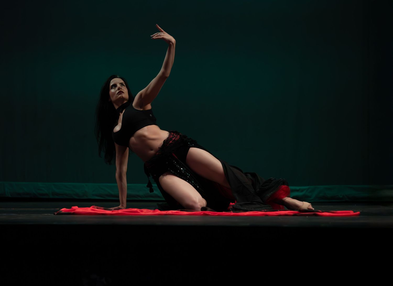 Female dancer performing at a dance recital in Maywood, NJ, captured in motion with graceful expression and vibrant costume on stage
