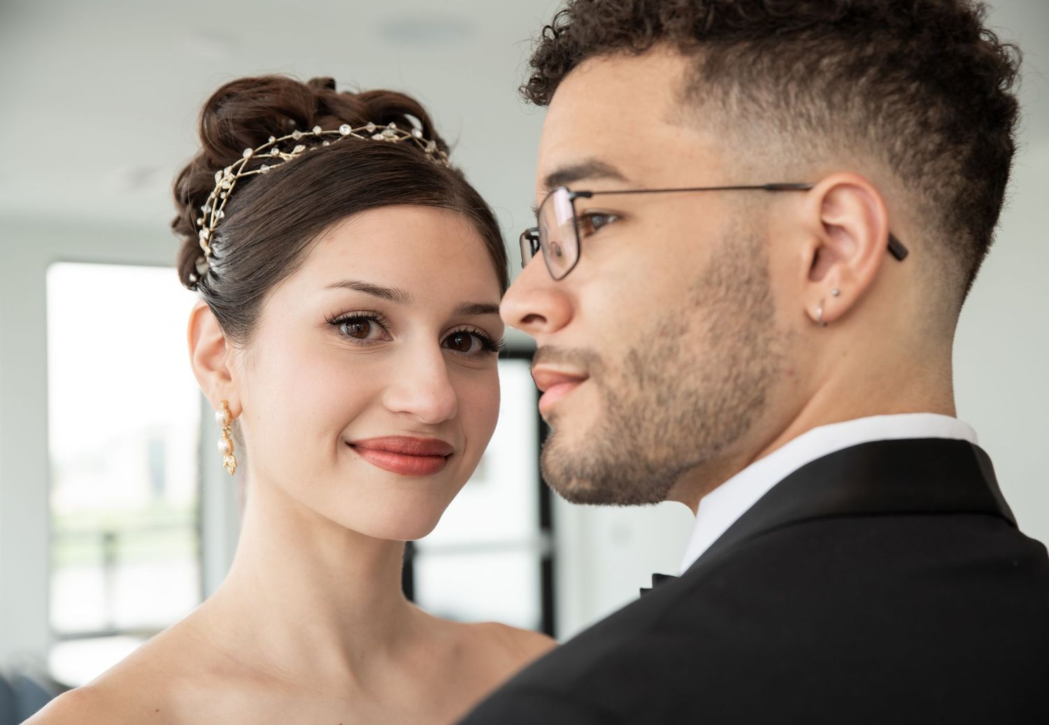 A portrait of a bride and groom as the bride is looking at the groom as he is looking away in Bayonne, NJ