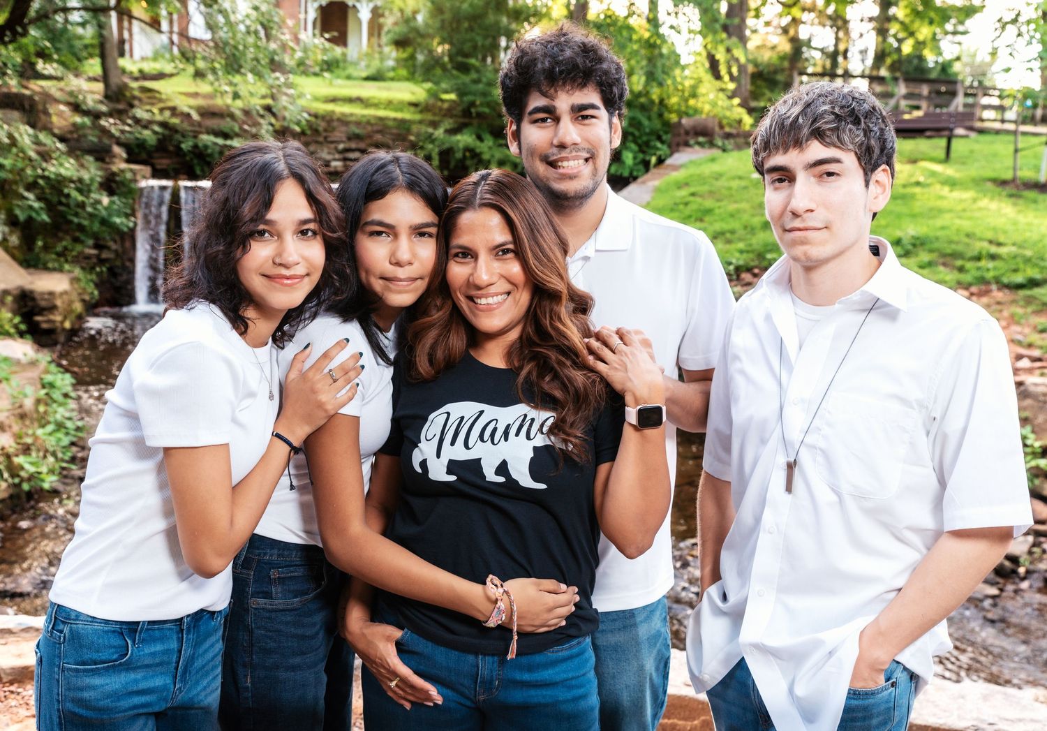 A mom with her 4 kids holds hands, and smiles during their family photo session in Nutley, NJ