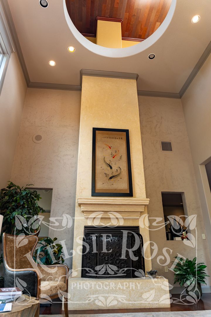 Tall interior fireplace with koi fish artwork in a high-ceiling office lobby space.