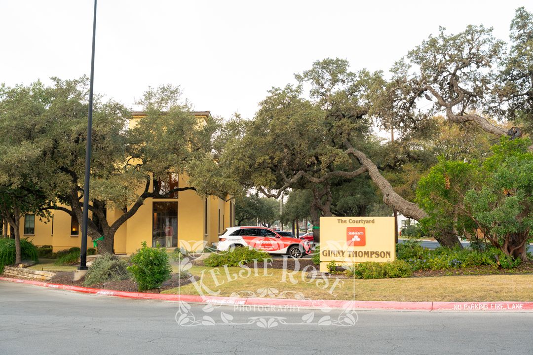 Yellow commercial building with Grant & Thompson signage surrounded by oak trees and landscaped grounds.