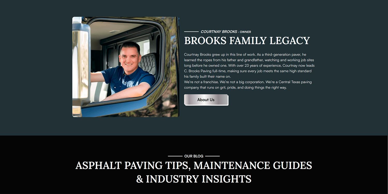 A smiling asphalt paving professional poses in a truck cab for the company website page.
