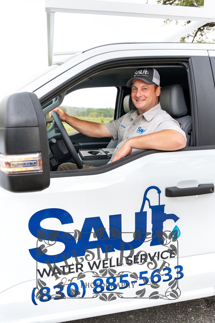 Saul Water Well Service technician smiling from white company truck.