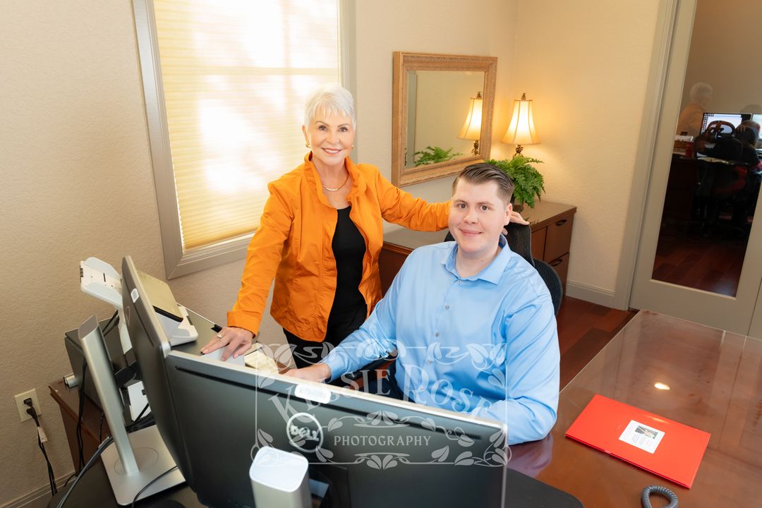 Professional man and woman collaborating at office desk with computer in modern business setting.