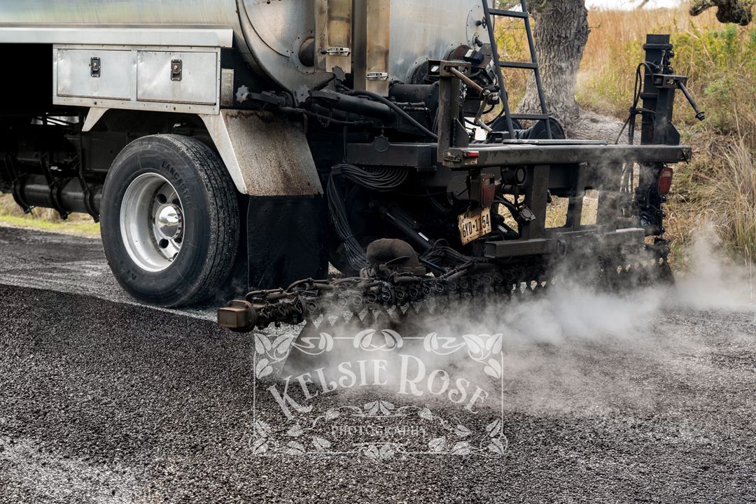 Steam rising from asphalt paving machinery during road construction work.