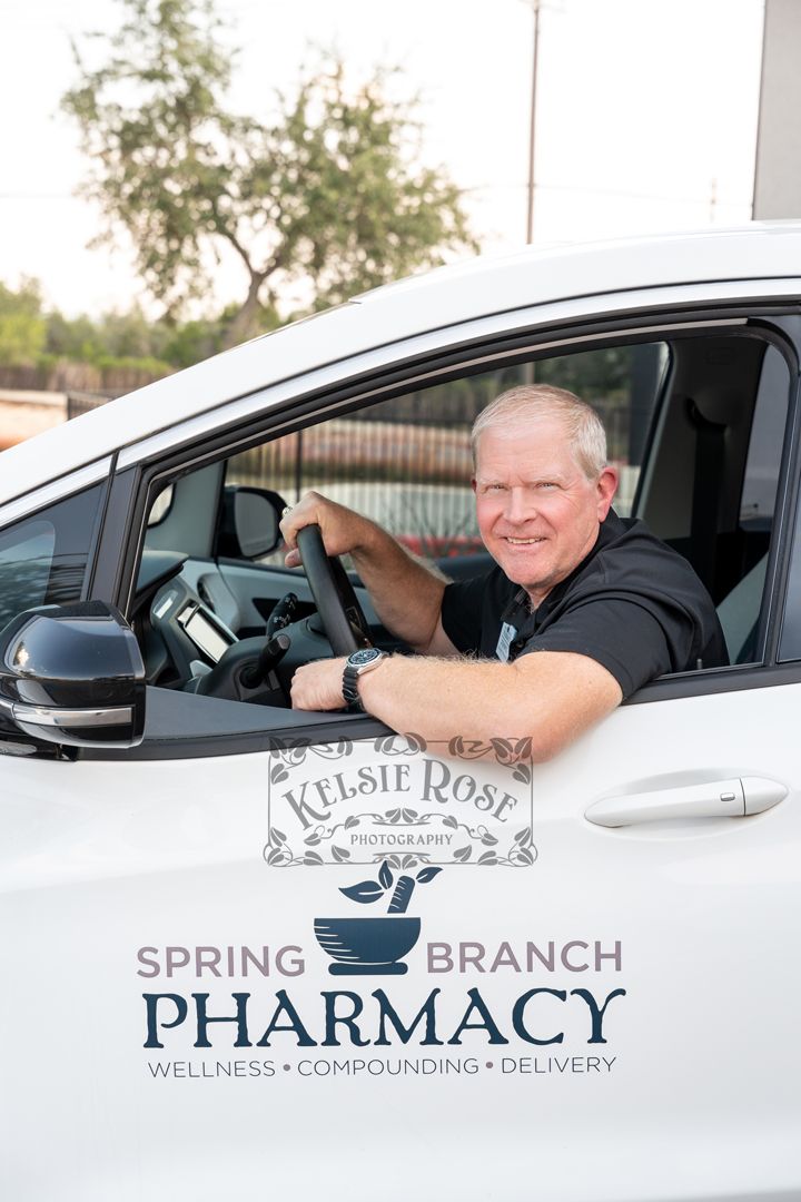 Man smiling in Spring Branch Pharmacy delivery car, representing wellness, compounding, and delivery services.