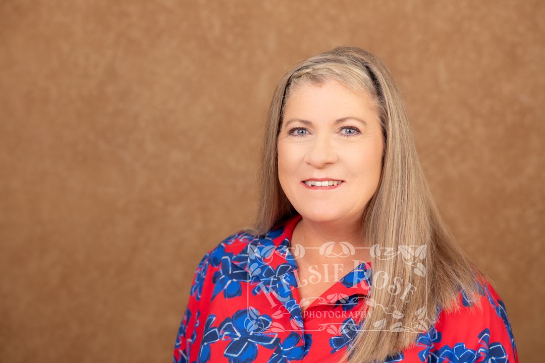 Professional headshot of Ginny Thompson, State Farm insurance agent, in red floral blouse.