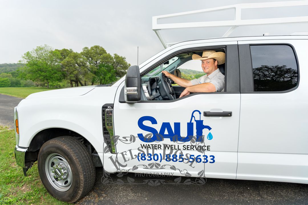 Saul Water Well Service employee driving branded white truck with company logo and phone number.