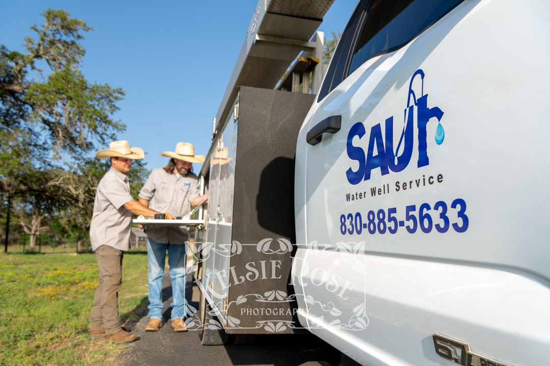 Saur Water Well Service technicians accessing tools from company truck.