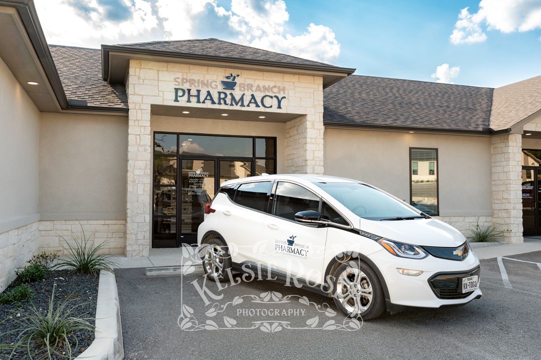 Spring Branch Pharmacy storefront with white delivery vehicle parked outside.