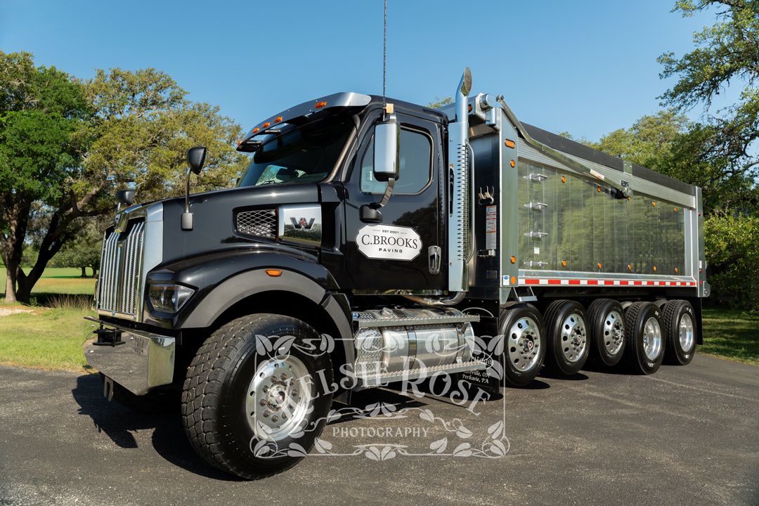 Black service truck with chrome details parked outdoors on a sunny day.