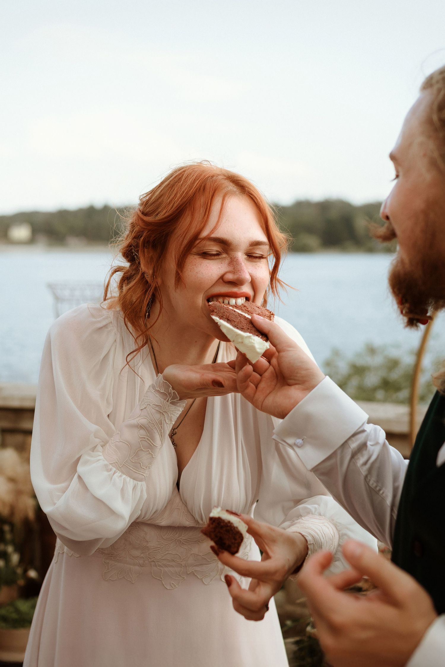 Nevesta ochutnáva svadobnú tortu počas svadobnej hostiny na terase Hotela Plumlov v Česku