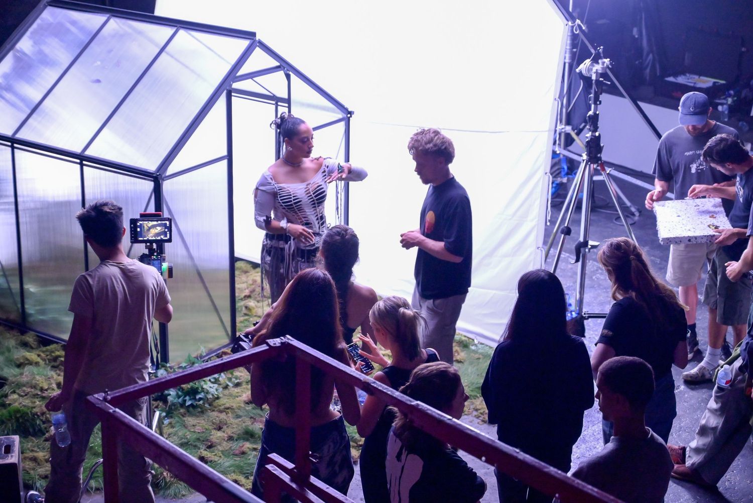 Film crew working together in a bright studio space during production.