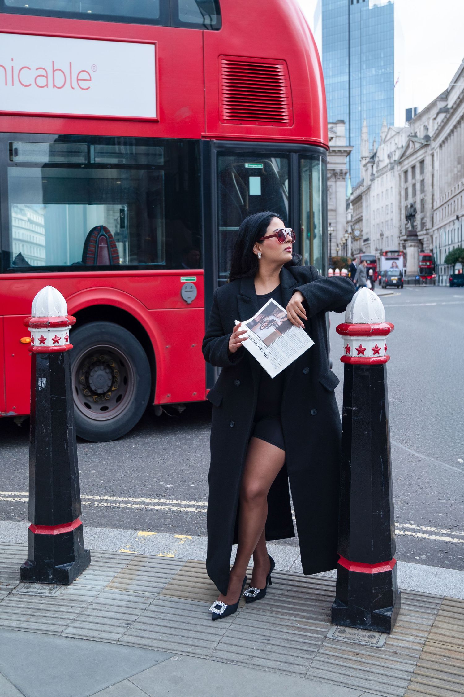 A series of photos showing someone playfully posing next to a red London bus and telephone booth in an urban setting.