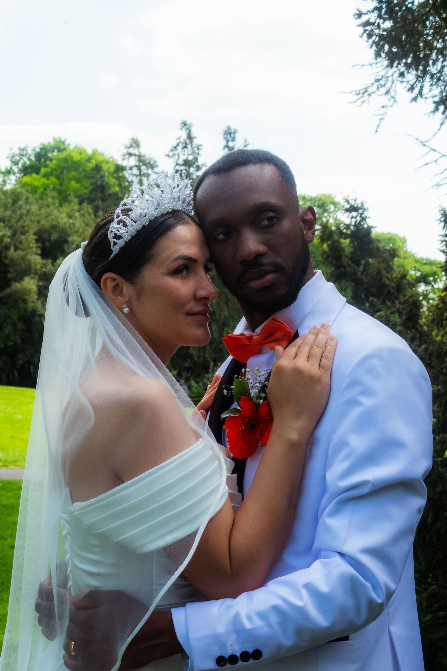 A romantic wedding portrait of a couple embracing in a garden setting.